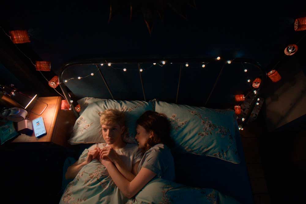 pareja lésbica de Feel Good en la cama