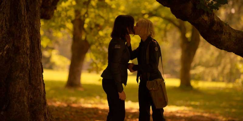 Raelle y Scylla besándose en el bosque