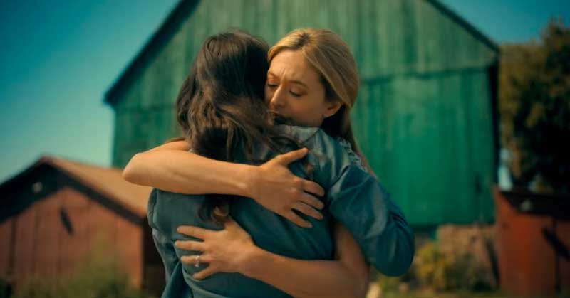 Vanya y Sissy abrazadas frente al granero