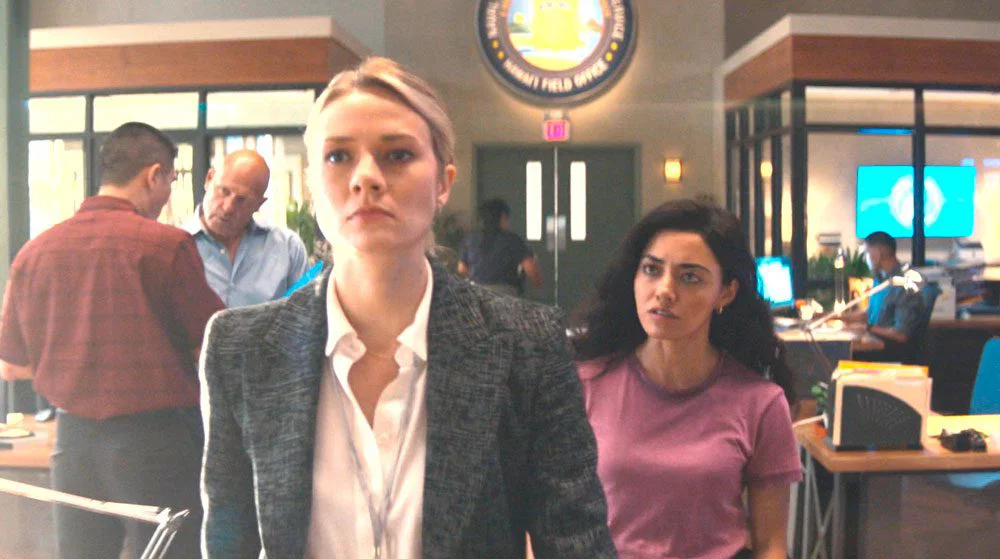 Lucy persiguiendo a Kate por la oficina
